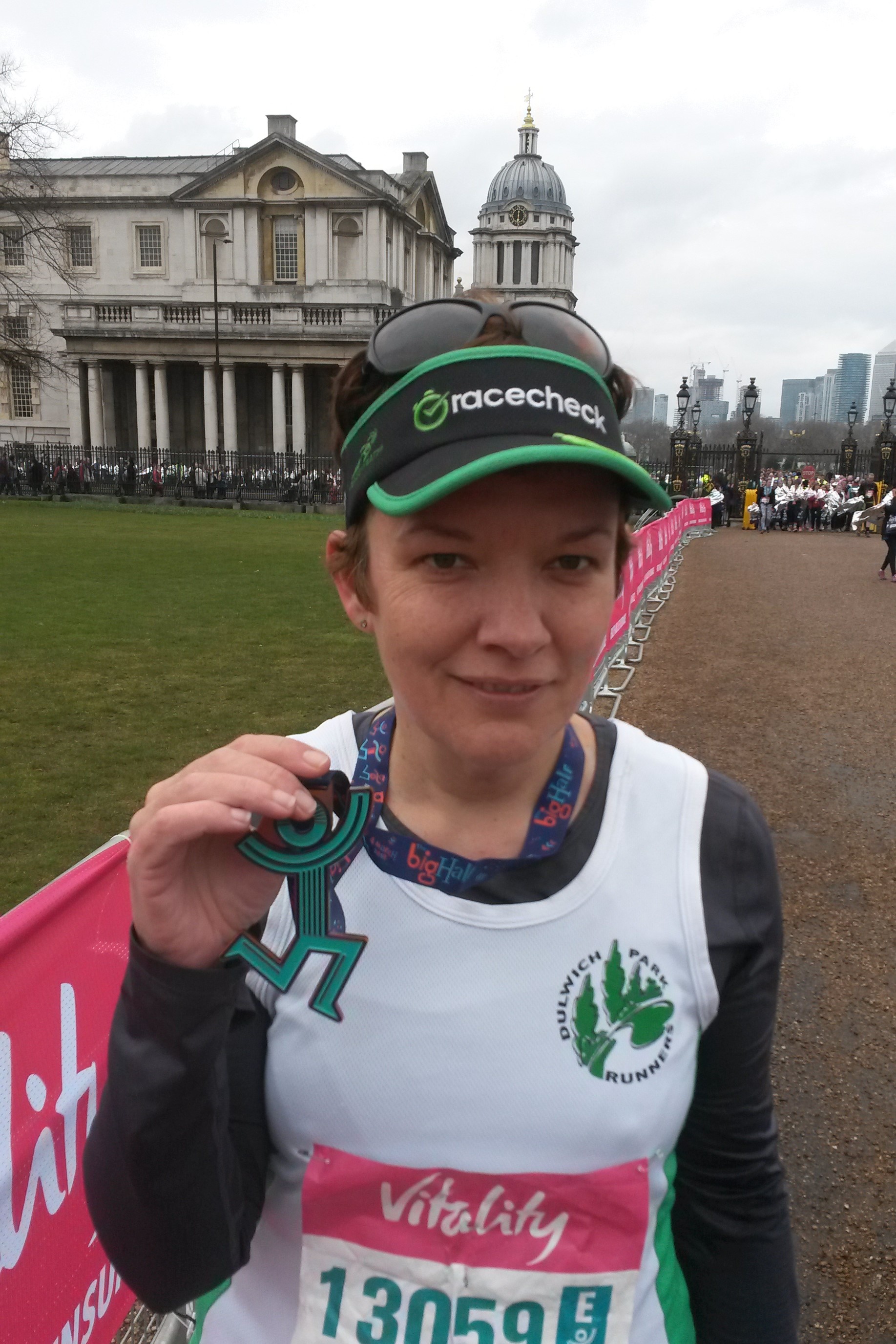 Standing at Greenwich after completing, holding up my medal