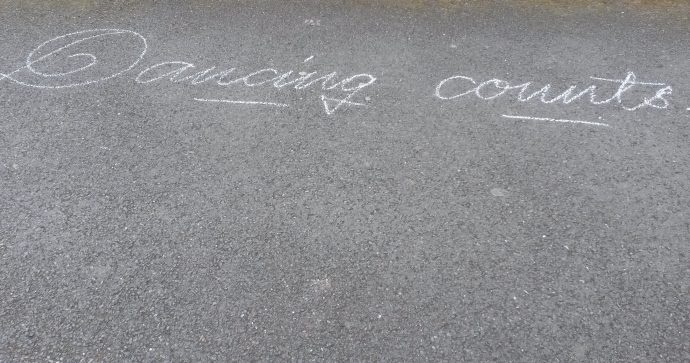 dancing counts written in chalk on footpath