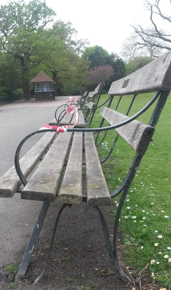 Park benches with tape to stop people sitting on them