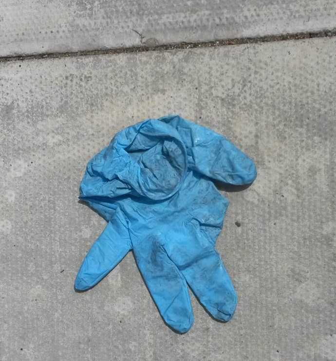 blue rubber glove discarded on the ground